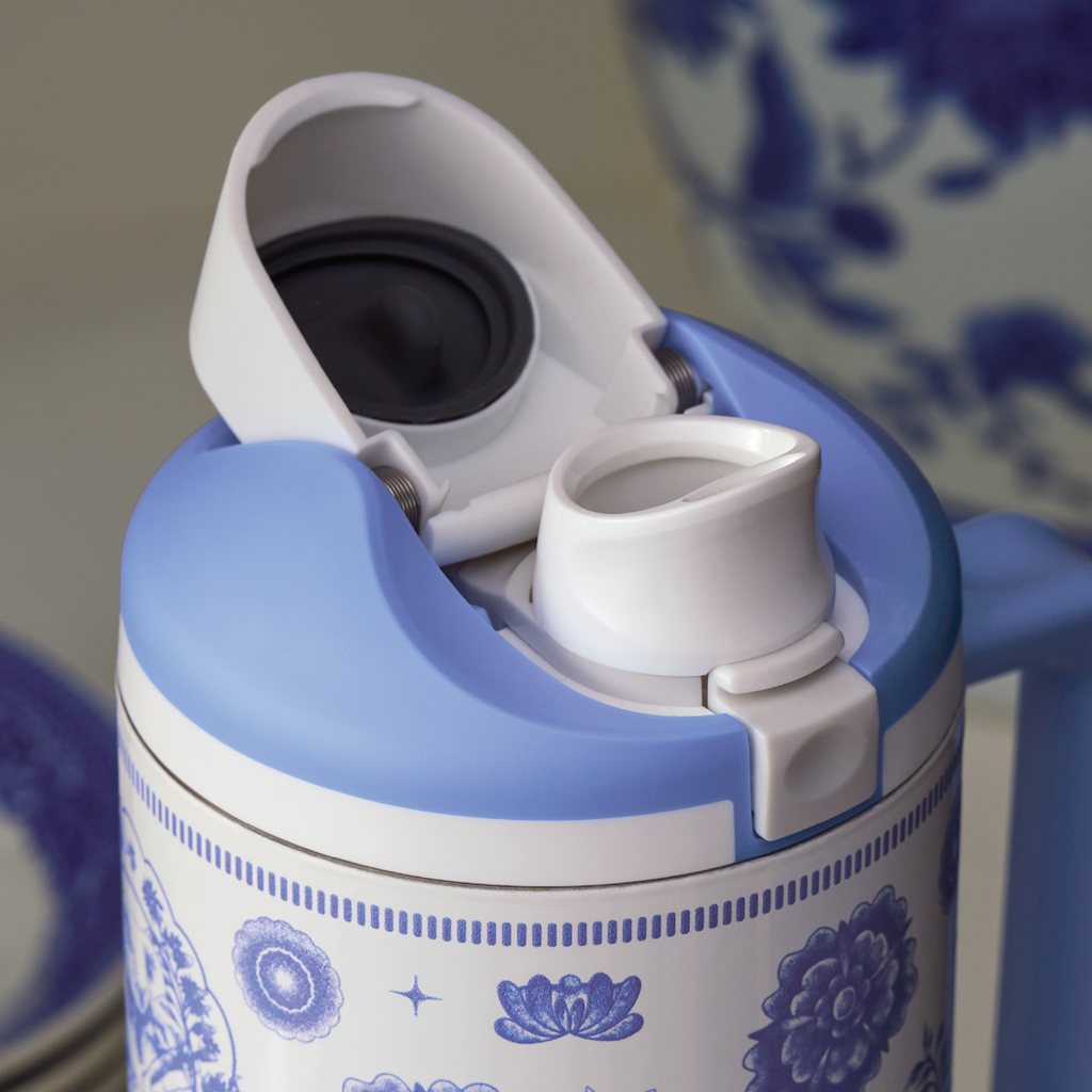Owala FreeSip lid detail in cobalt blue floral medallion print, flip cap open showing white FreeSip spout